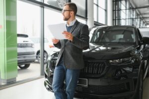 Man looking at a car in a clean auto dealership