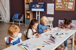 Table of children working on art at a clean daycare facility
